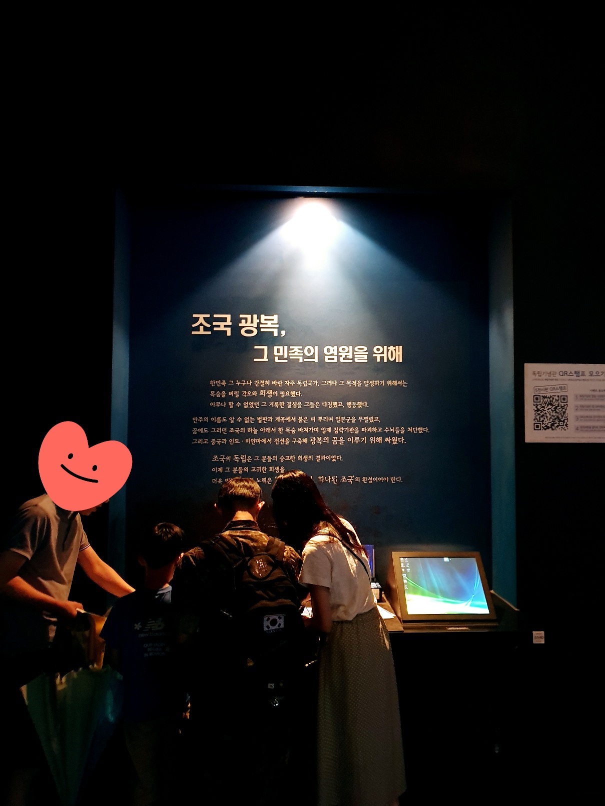 독립기념관 실내 전시 공간에서 ‘조국 광복, 그 민족의 염원을 위해’라는 문구가 조명 아래 강조된 장면. 방문객들이 전시 자료를 열람 중이다.