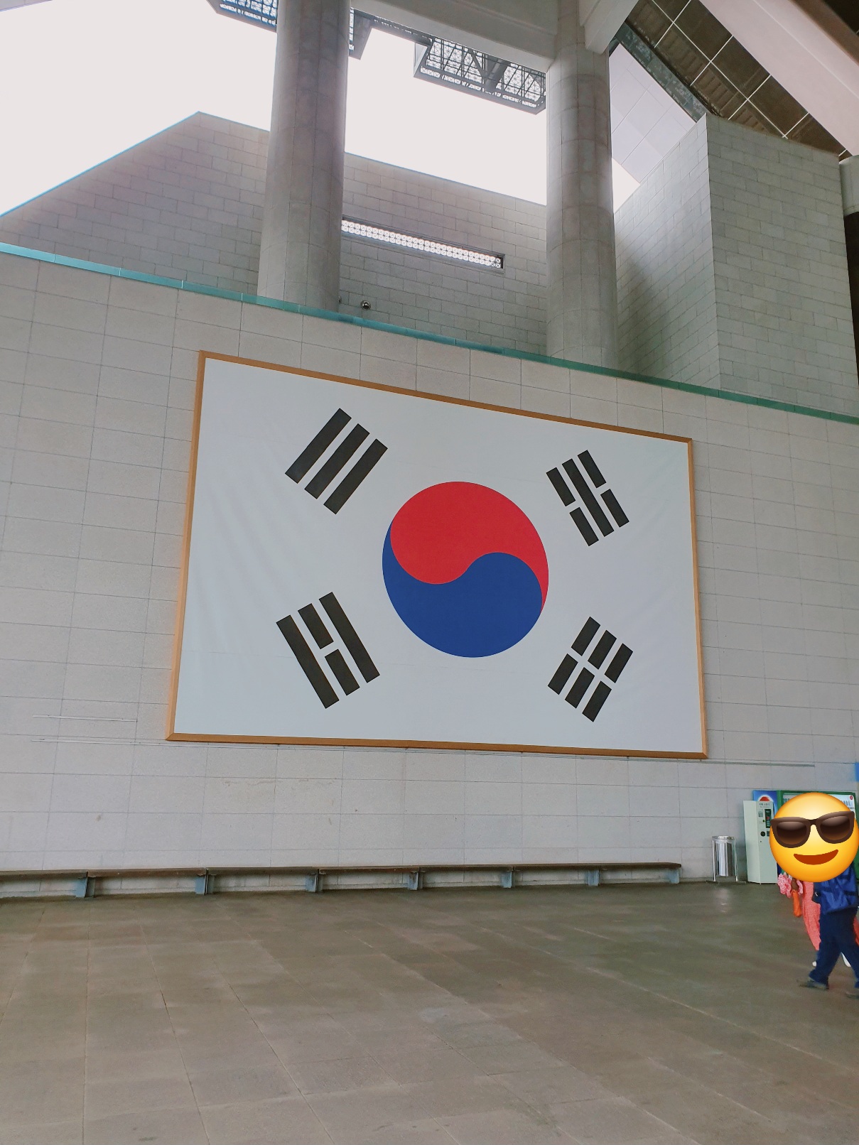 독립기념관 외부 대형 태극기 전시 공간. 탁 트인 천장 아래 위치한 상징적인 태극기와 관람객 모습이 함께 담긴 장면.