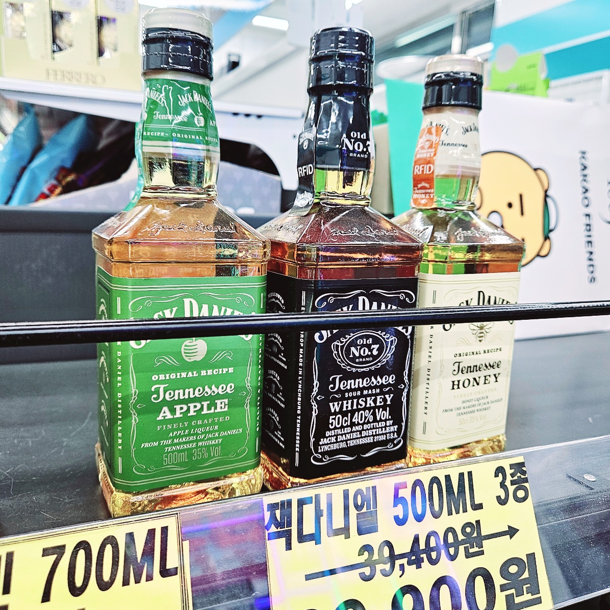 편의점 GS25에 진열된 잭다니엘 500ml 위스키 3종 – 애플, 오리지널, 허니 제품. 할인 가격 29,900원으로 판매 중이며, 각각의 제품이 전면에 잘 보이도록 나란히 진열되어 있다.