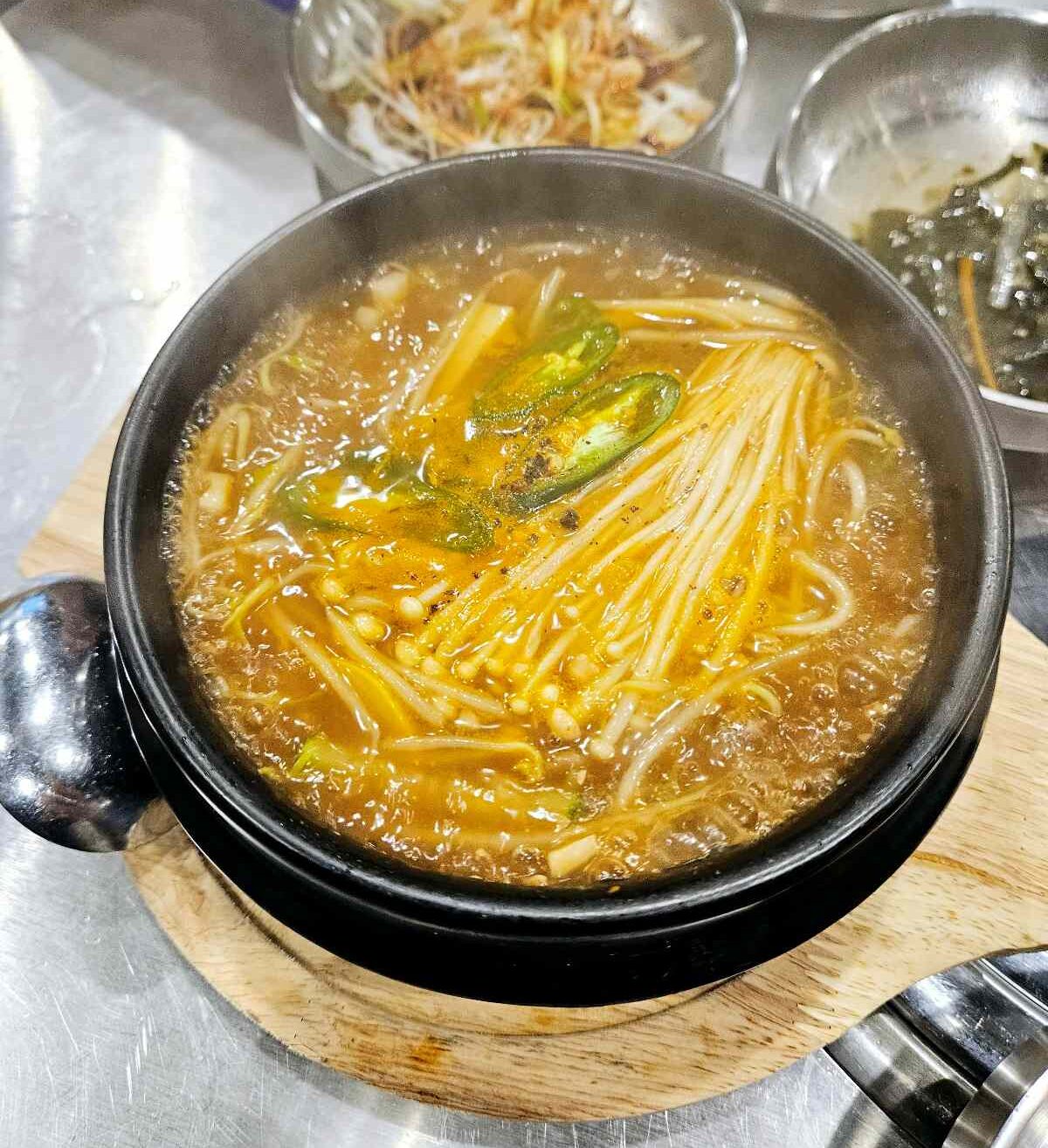 한국식 된장찌개 위에 고추와 팽이버섯이 올라간 나트랑 육몽 음식 사진